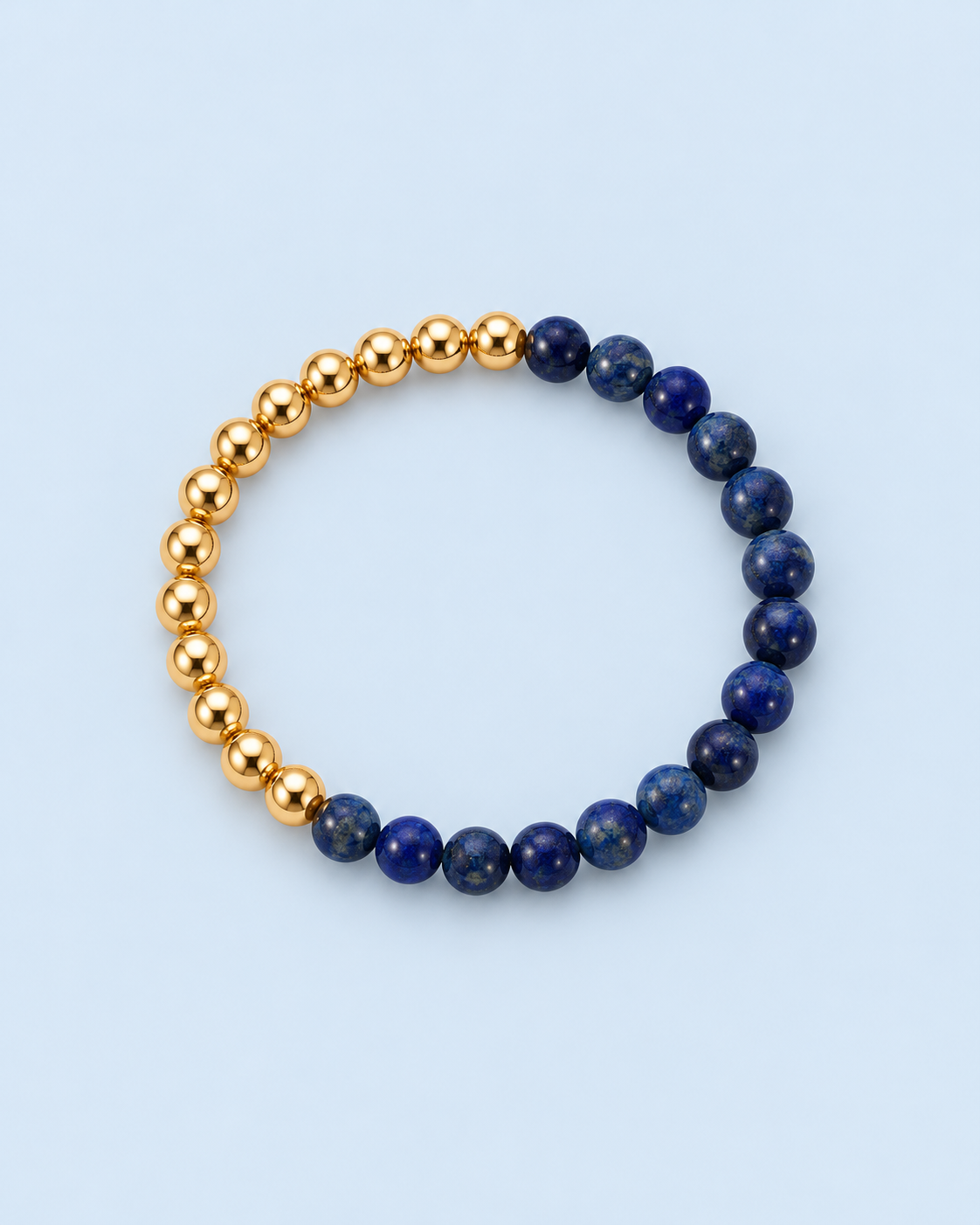 Individual Indi two-tone bracelet from The Riann Ashlyn Collection, featuring sections of 14K gold-filled and genuine lapis lazuli beads on a pale blue background.
