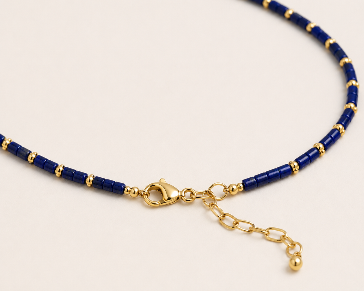 Close-up of the Navy Lapis Necklace showing genuine lapis lazuli beads, 18K gold-plated details, lobster clasp, and extender chain.
