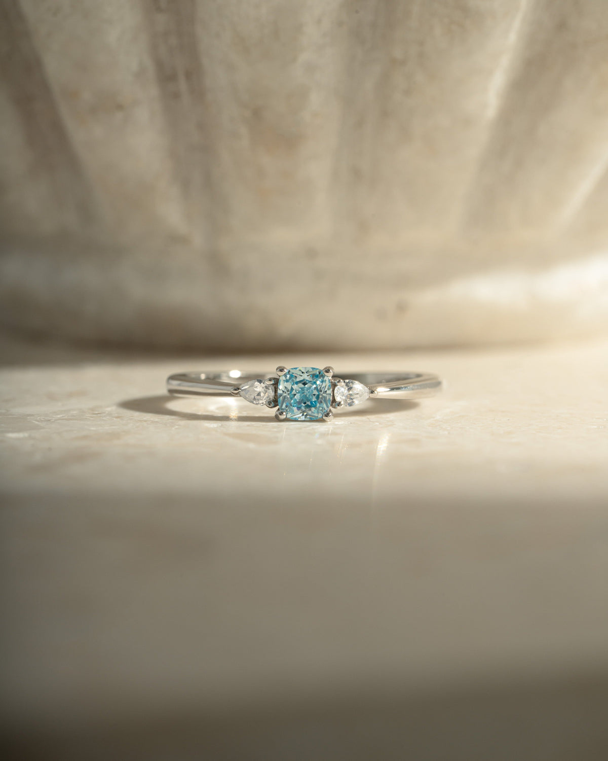 Kennedy Aquamarine Blue Cushion Ring with blue cushion-cut cubic zirconia and clear side stones