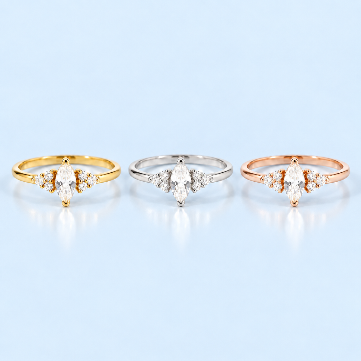 Ari Marquise Ring shown in gold, silver and rose gold finishes on Riann Ashlyn blue background