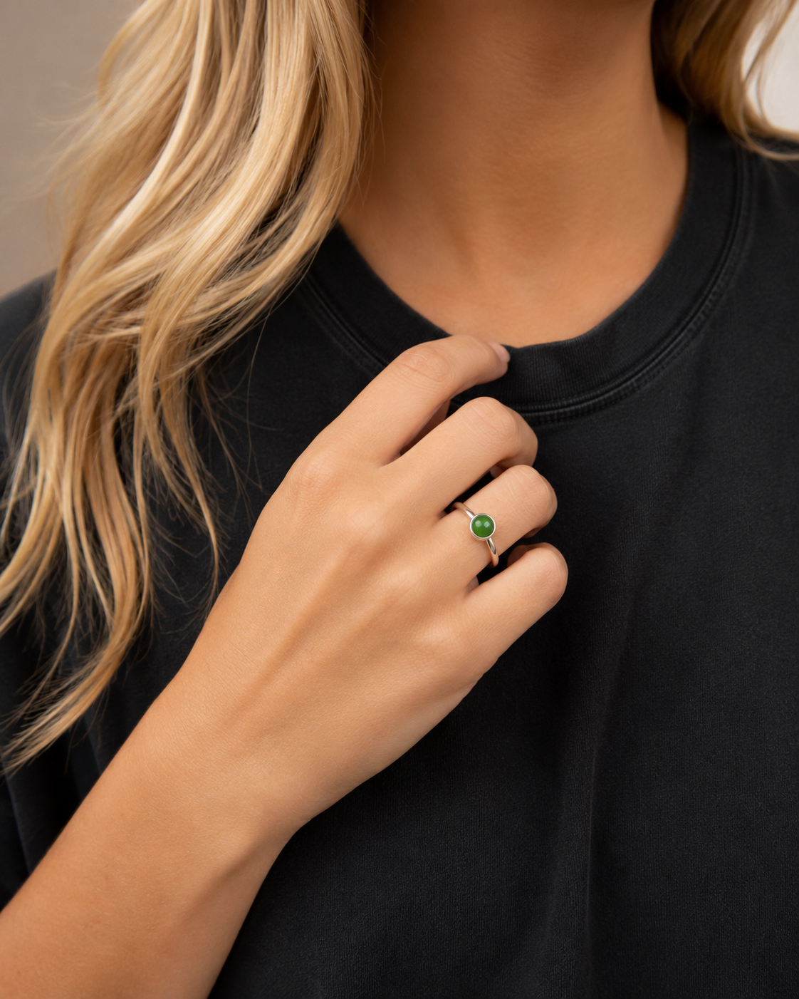     Woman wearing the Blaise sterling silver ring with a round green nephrite jade cabochon and black tee.