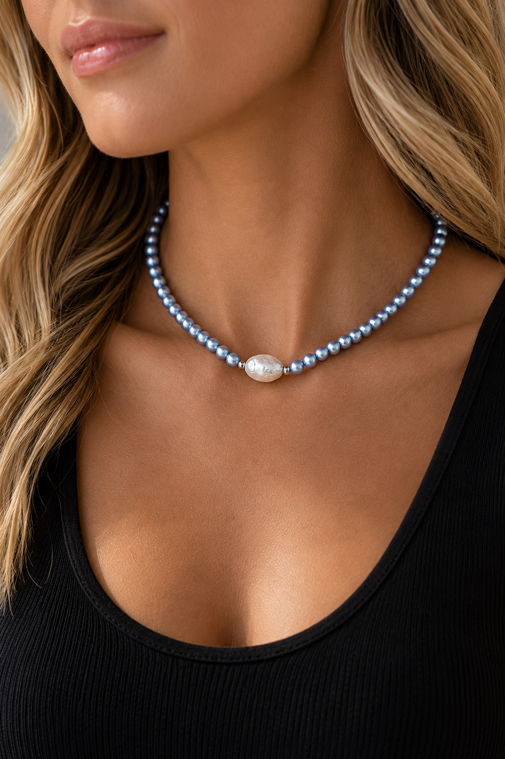 Model wearing the Blu Pearl Necklace with light blue pearl beads and a single irregular white freshwater pearl centerpiece with a black tank top.