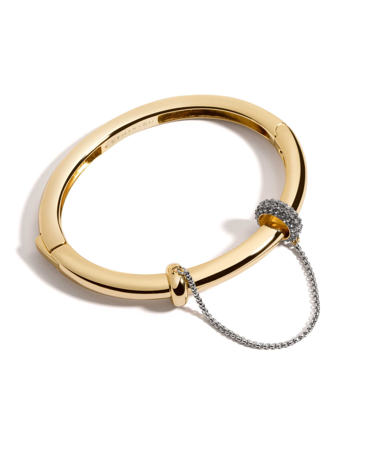 Channing Sculptural Bangle Bracelet from The Riann Ashlyn Collection, featuring a polished gold-tone band, pavé rondel accent, and connecting chain on a white background.