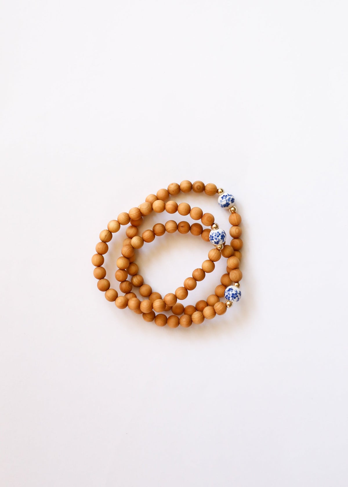 Cypress wood beaded bracelets grouped together, showing hand-painted blue floral porcelain beads, The Riann Ashlyn Collection