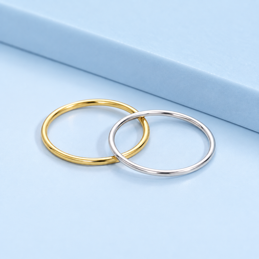     Eden Sterling Silver Stack Ring in gold-plated and platinum-plated finishes on a light blue background