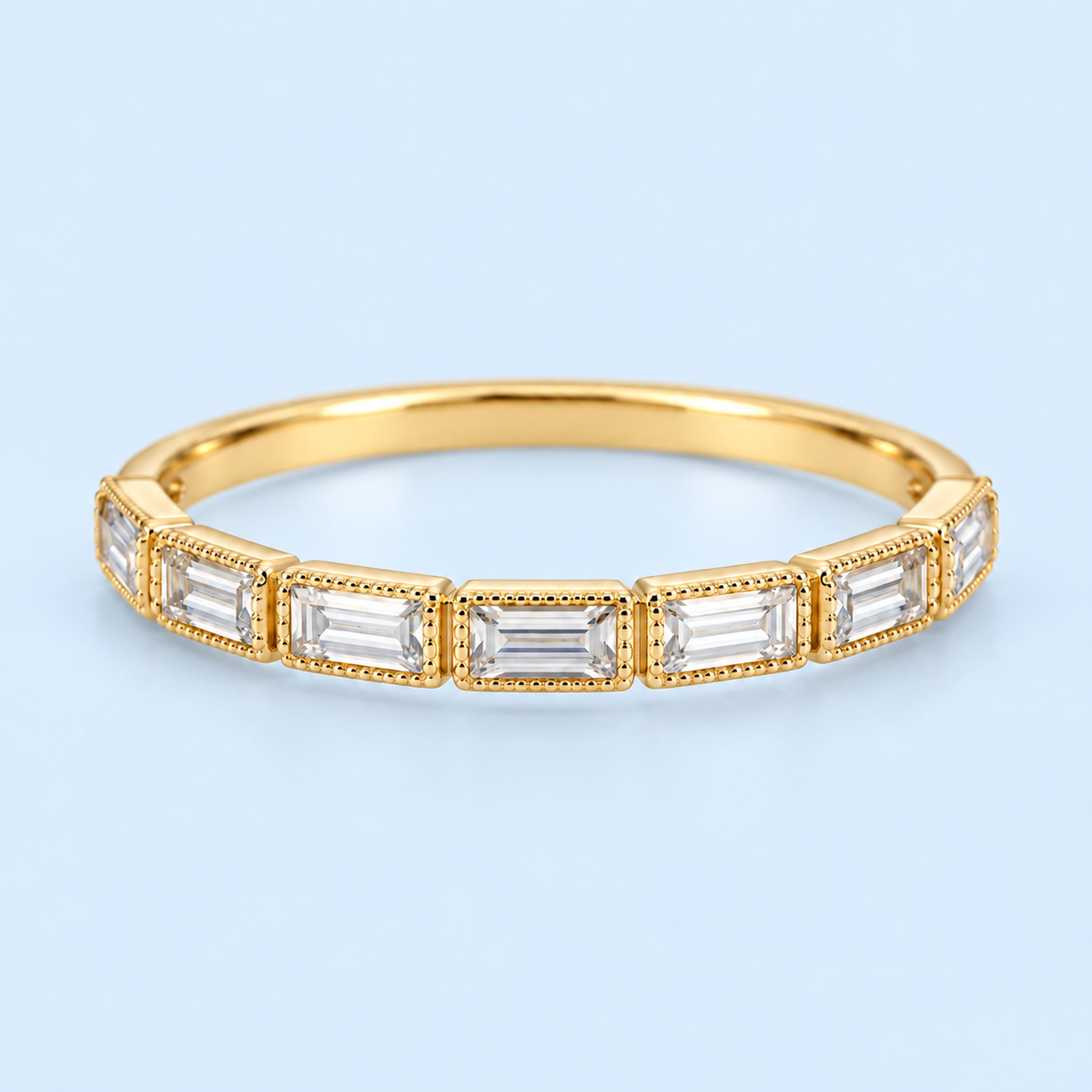 Fallon gold-plated baguette ring on light blue background