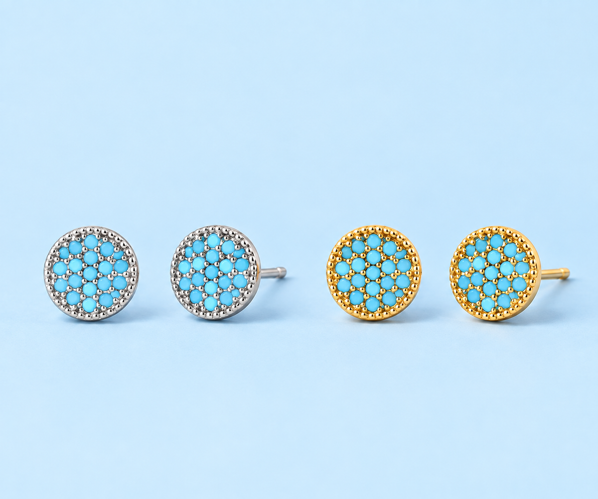     Gemma natural turquoise stud earrings in silver and gold on a light blue background