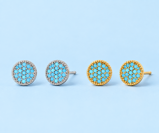     Gemma natural turquoise stud earrings in silver and gold on a light blue background