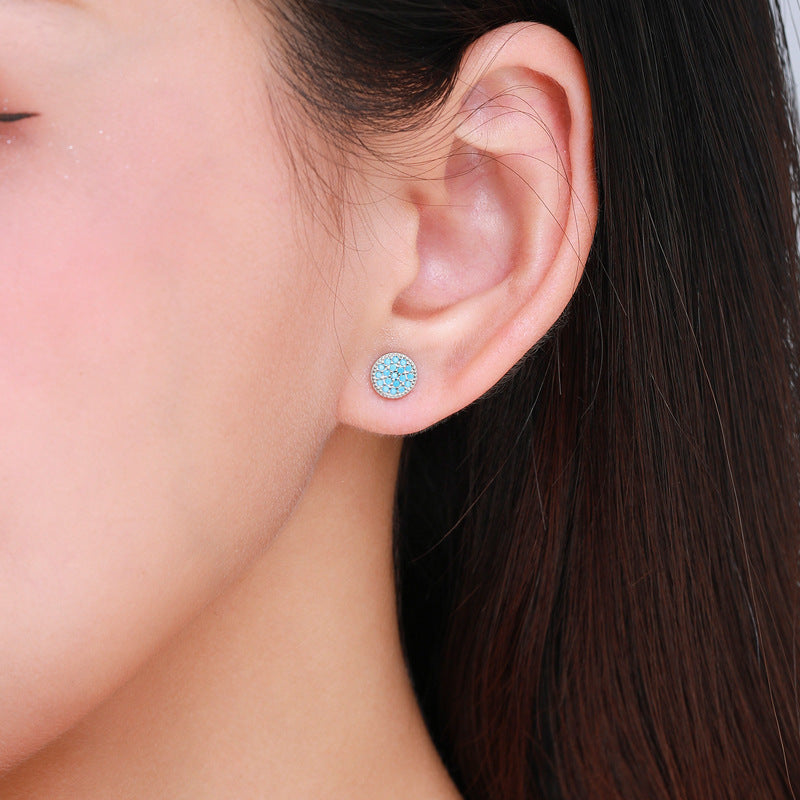     Model wearing Gemma natural turquoise stud earrings in silver