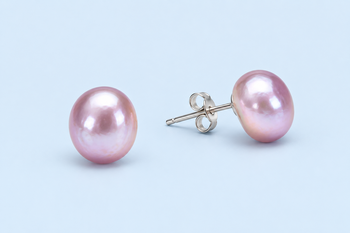 Pair of Hadley lavender pearl stud earrings on a pale blue background, with one post and butterfly back visible