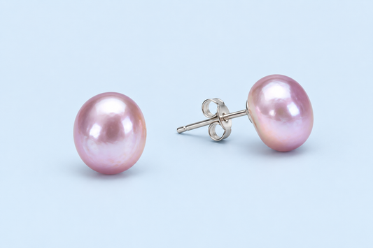 Pair of Hadley lavender pearl stud earrings on a pale blue background, with one post and butterfly back visible