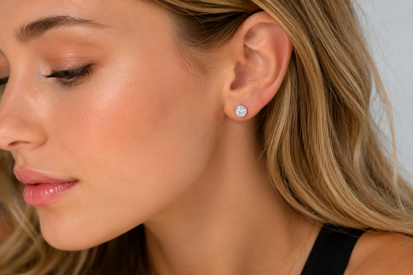 Model wearing a Harper sterling silver simulated diamond stud earring in a round bezel setting.
