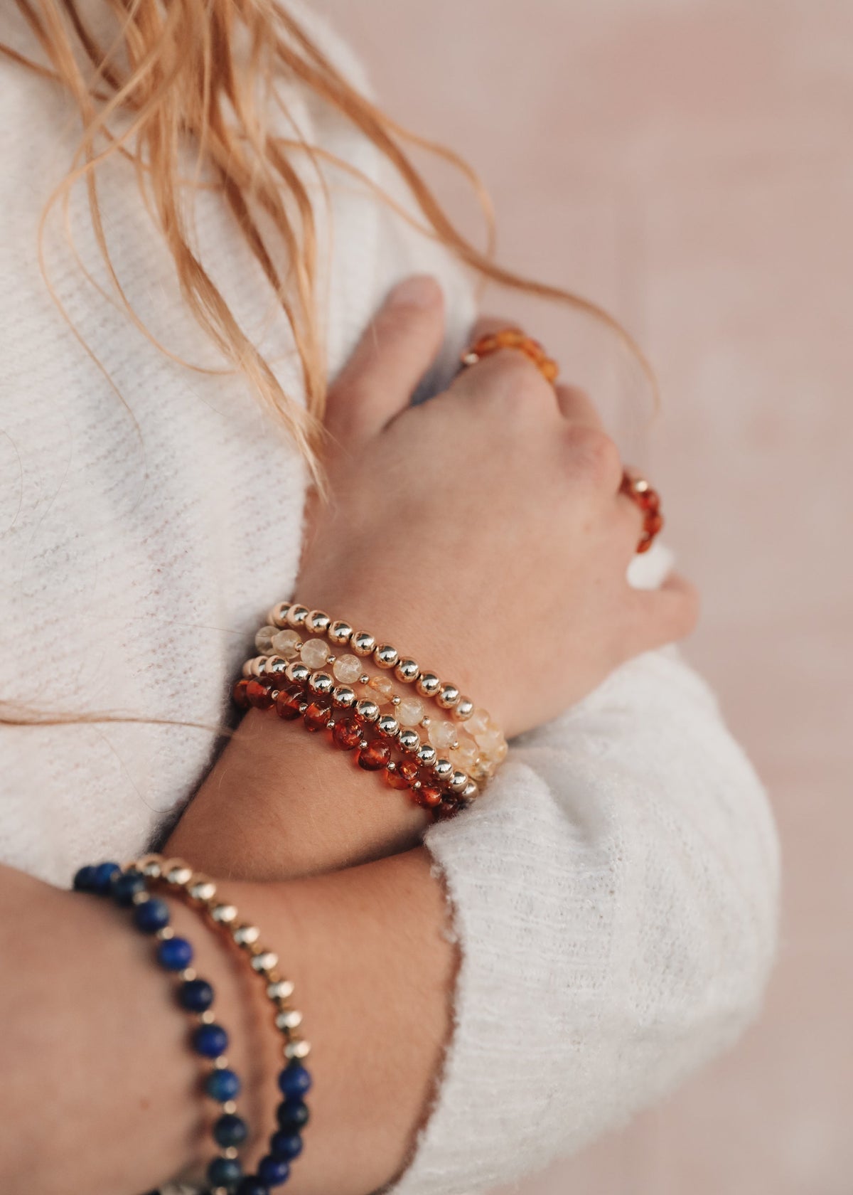 Indi lapis lazuli beaded bracelet styled alongside other bracelets on a model wearing a cream sweater for The Riann Ashlyn Collection.