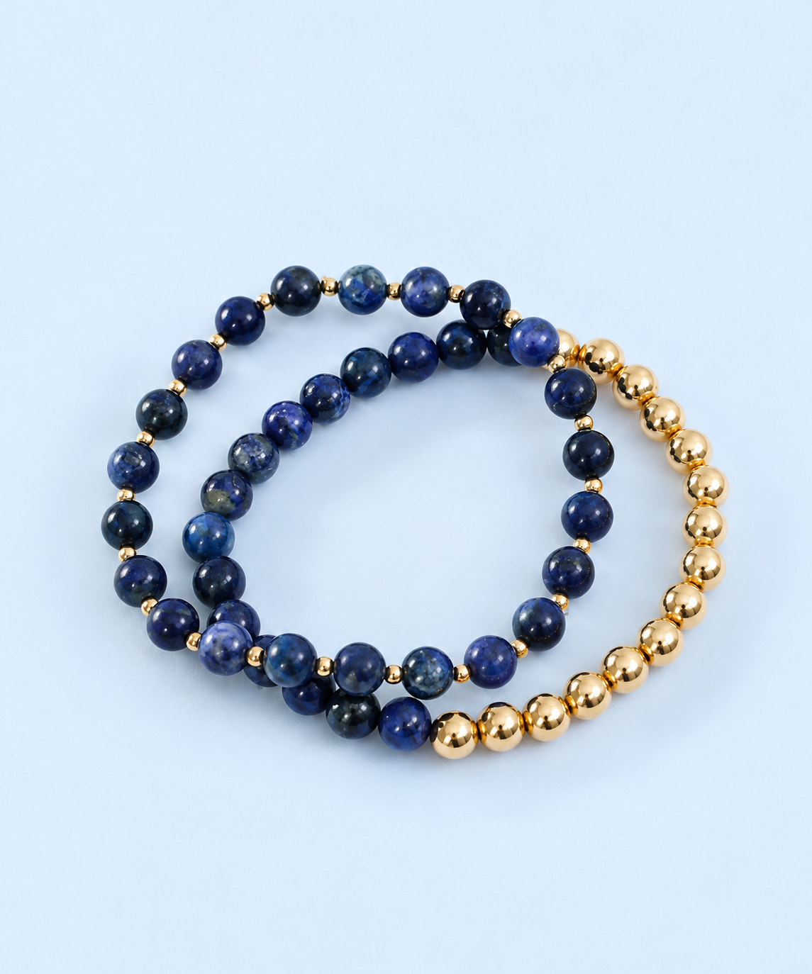 Indi Sun + Moon matching bracelet set from The Riann Ashlyn Collection, with deep blue lapis lazuli and gold-filled beads on a pale blue background.