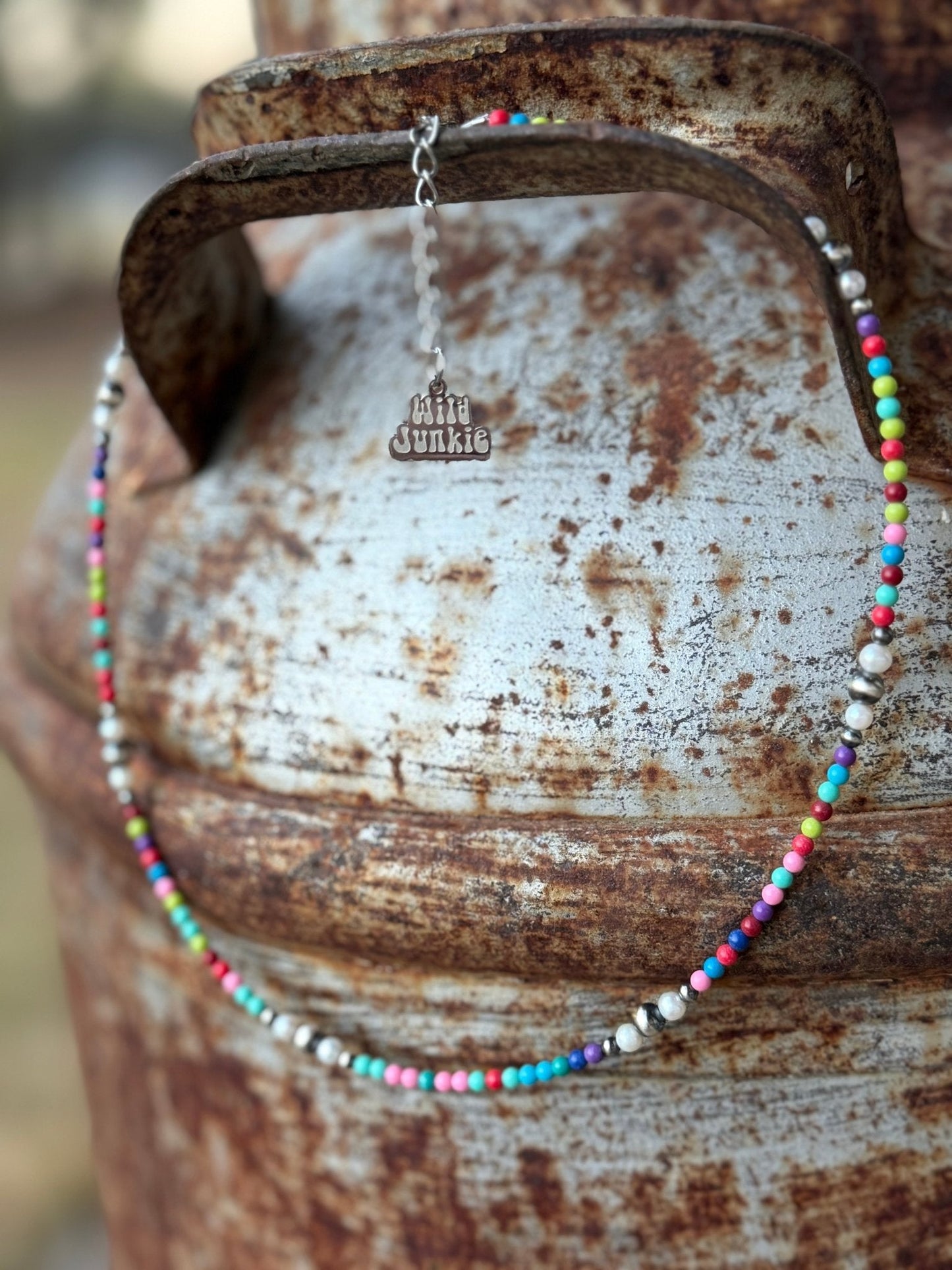 Indy Necklace with multicolor beads, sterling silver beads and genuine freshwater pearls displayed on a rustic metal background.