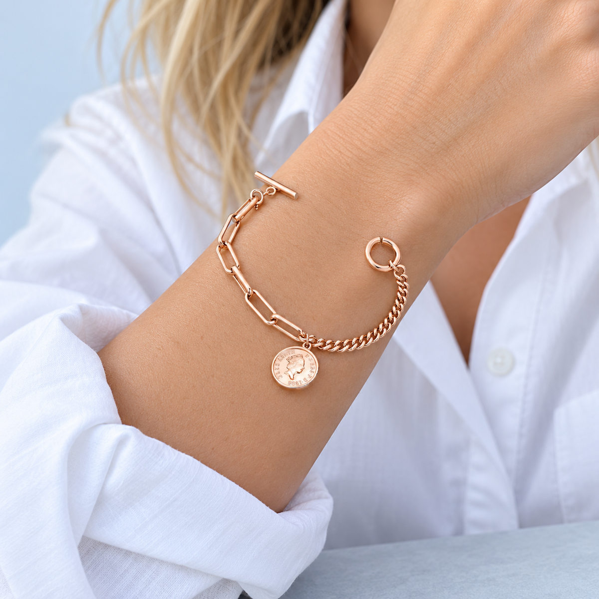 Model in a white shirt wearing the Jovie coin charm bracelet