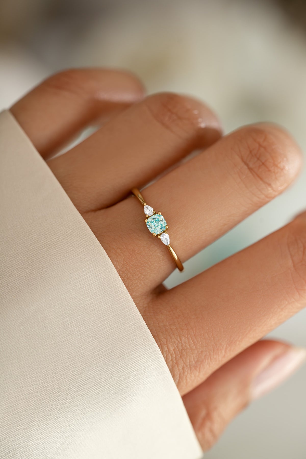 Gold Kennedy Aquamarine Blue Cushion Ring with blue cubic zirconia worn on hand