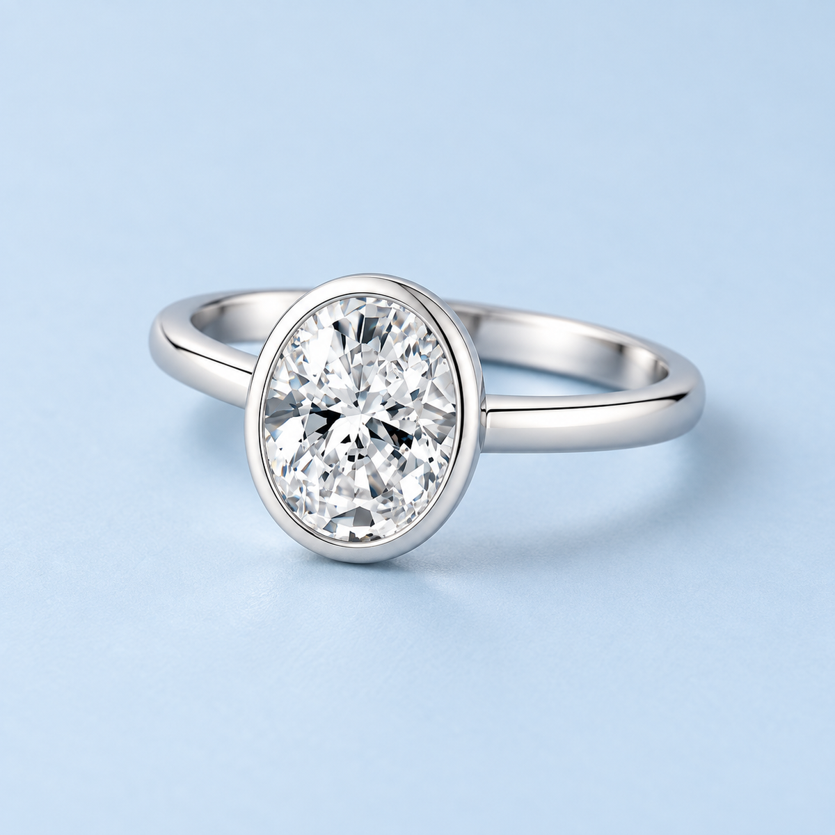 Leighton oval moissanite bezel ring on a Riann Ashlyn blue background