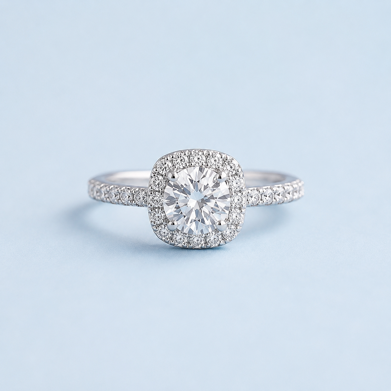 Madison sterling silver halo ring with a white moissanite center stone and pavé-set band on a light blue background.