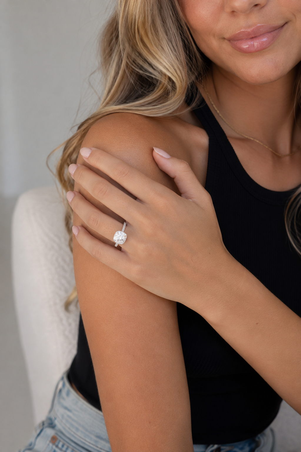 Madison sterling silver halo ring with a white moissanite center stone worn by a model in a black tank top.