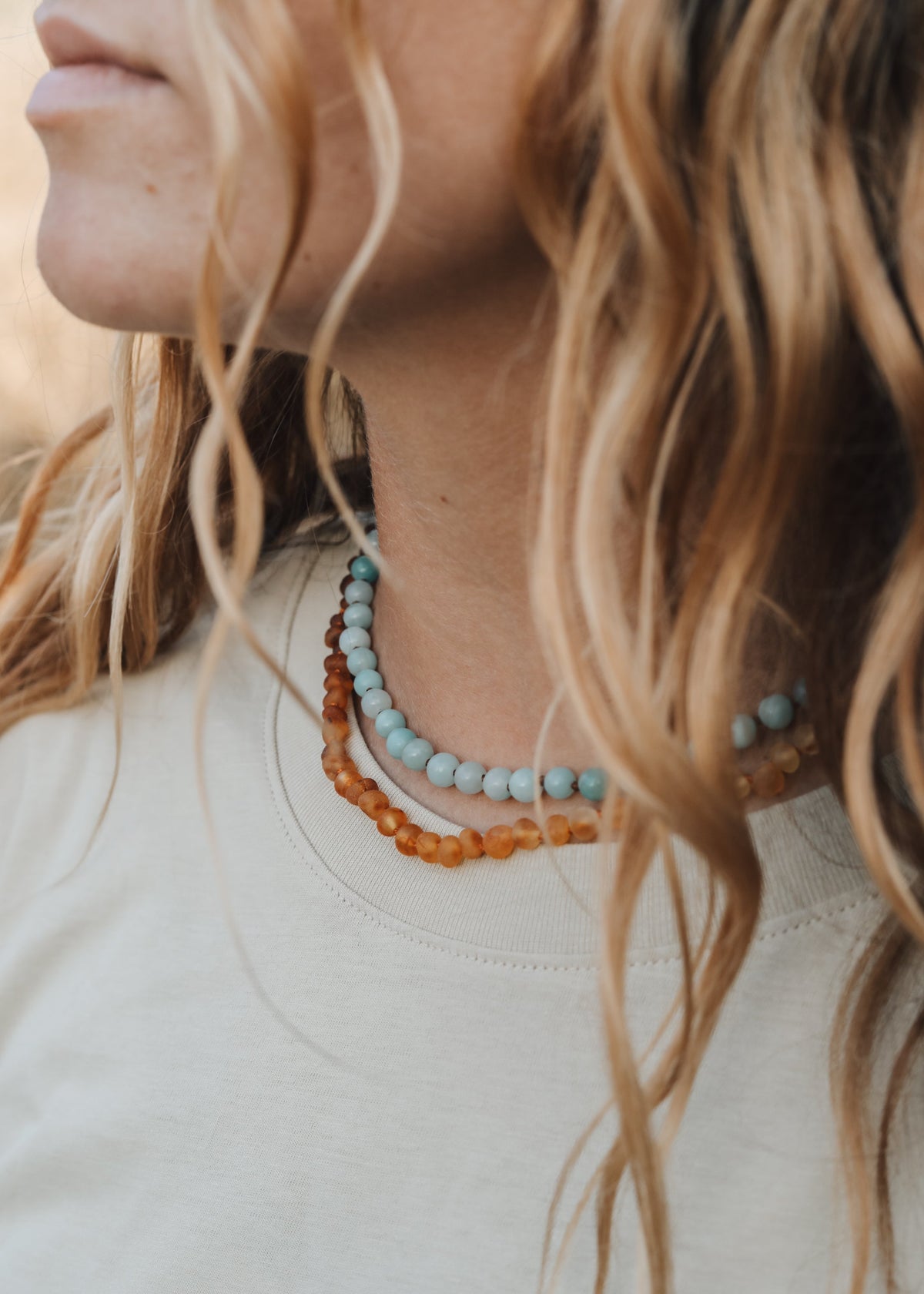 Maren Amazonite Gemstone Necklace from The Riann Ashlyn Collection styled on a model with layered beaded necklaces.
