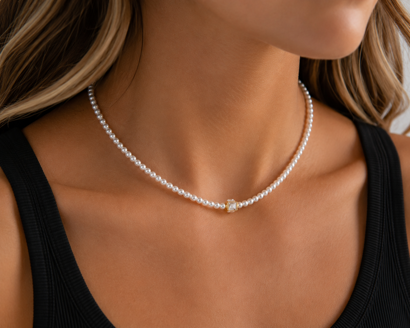 Marissa faux pearl necklace with a clear square crystal center worn with a black tank top.