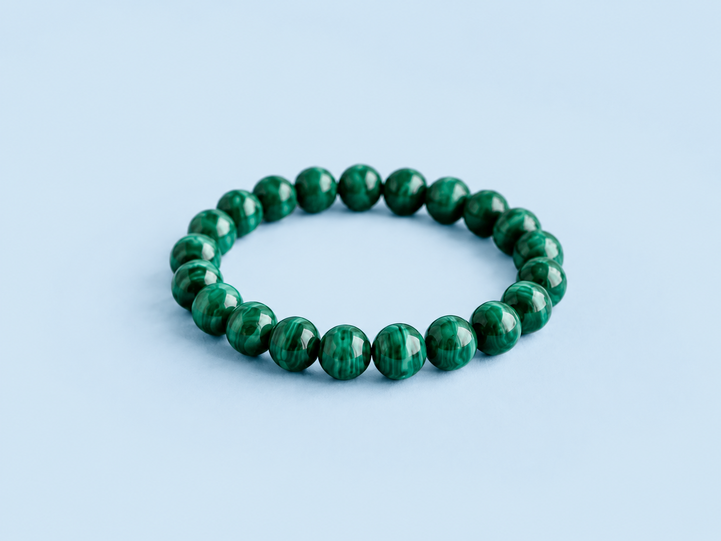 Mazzy natural malachite beaded bracelet on a light blue background