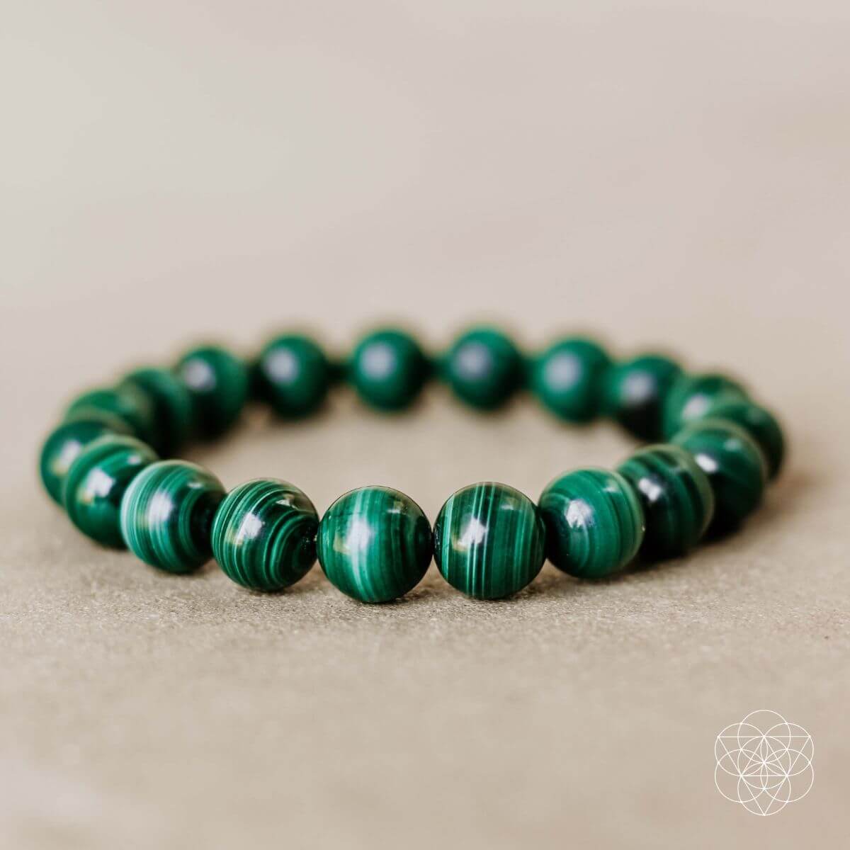 Close-up of Mazzy natural malachite bracelet showing green banded stone patterns.