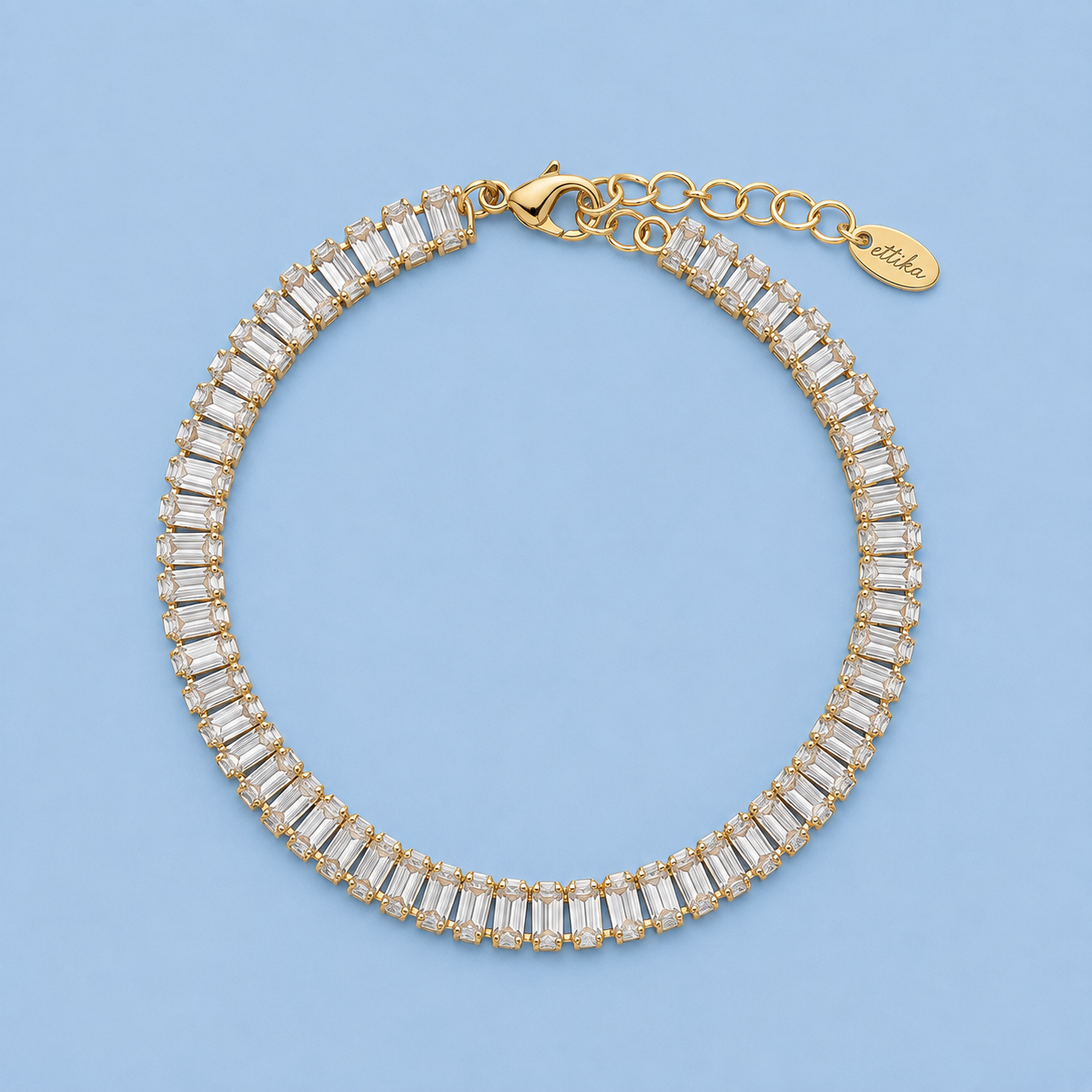 Moxie clear baguette cubic zirconia anklet with gold-tone setting on light blue background