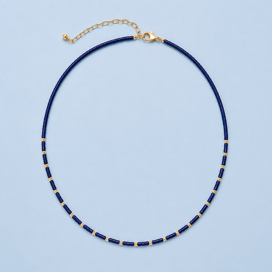 Navy Lapis Necklace with genuine lapis lazuli beads and 18K gold-plated details on a light blue background.