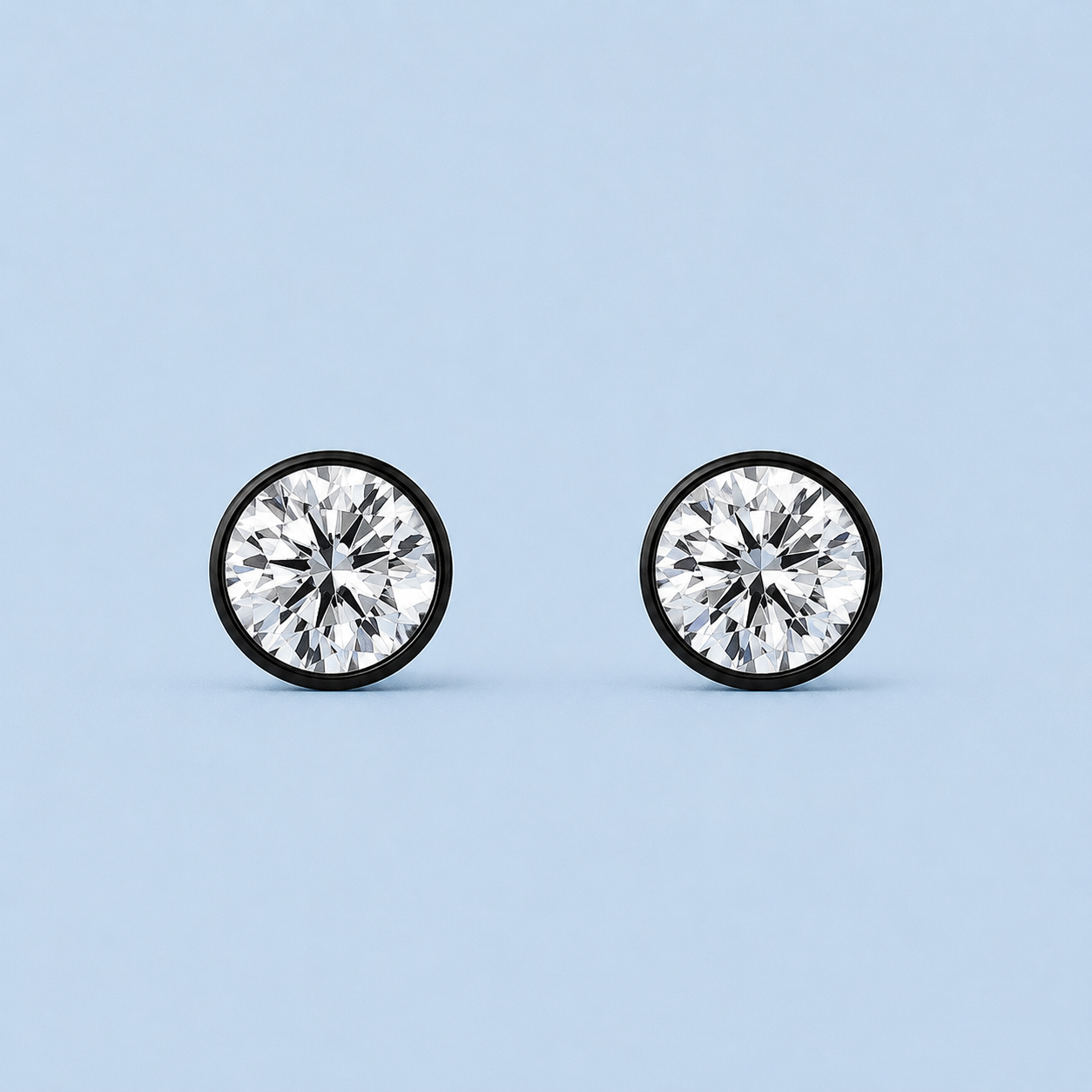 Noir Solitaire Stud Earrings with round diamond-alternative stones in black settings on pale blue background