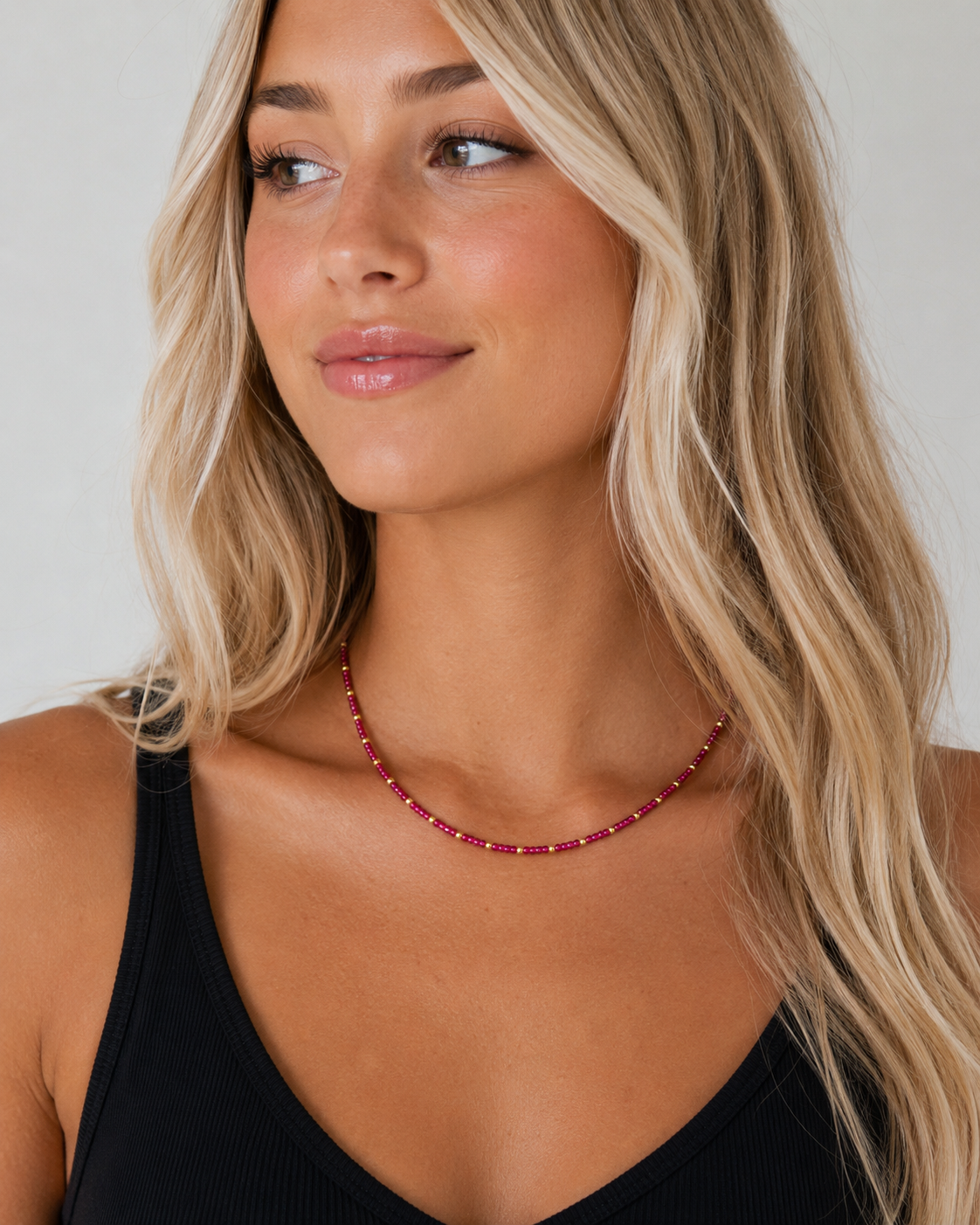 Model wearing the Rory Ruby Necklace with ruby-toned beads and gold-tone accents.