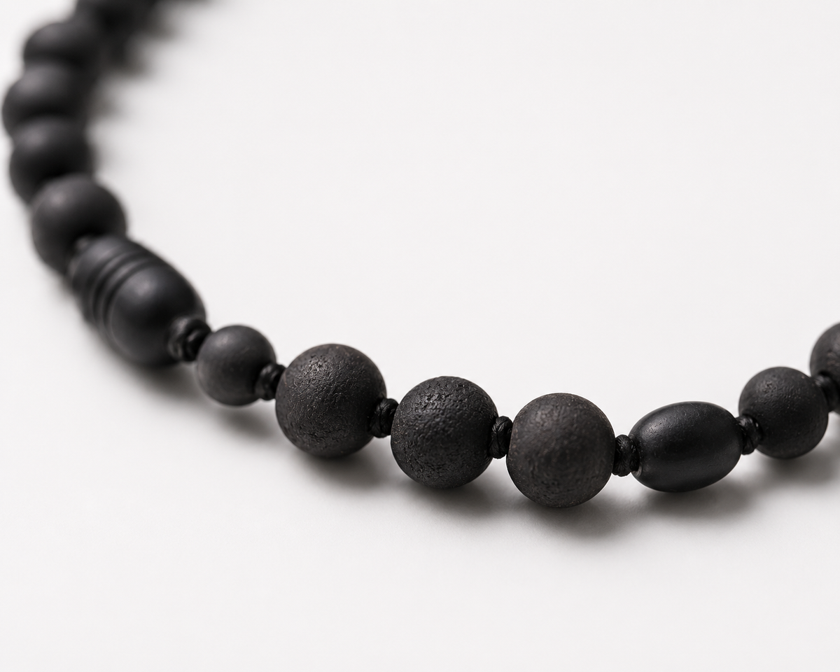 Close-up of Salem black Baltic amber and shungite necklace showing matte and textured round beads