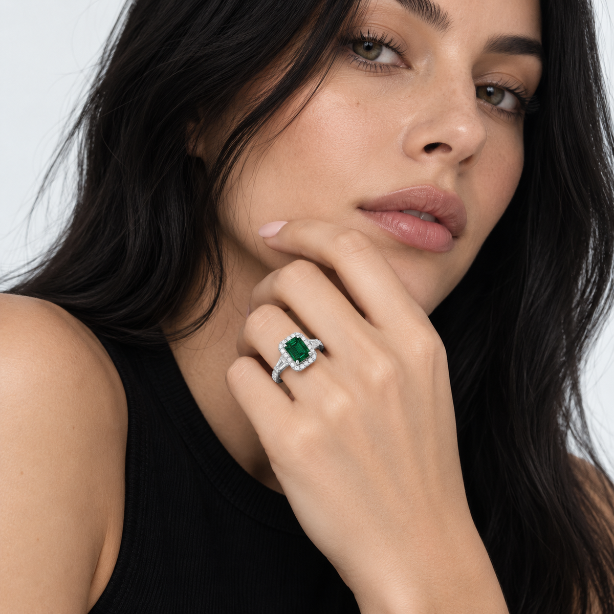 Model wearing the Senna emerald-cut green moissanite ring with a black sleeveless top
