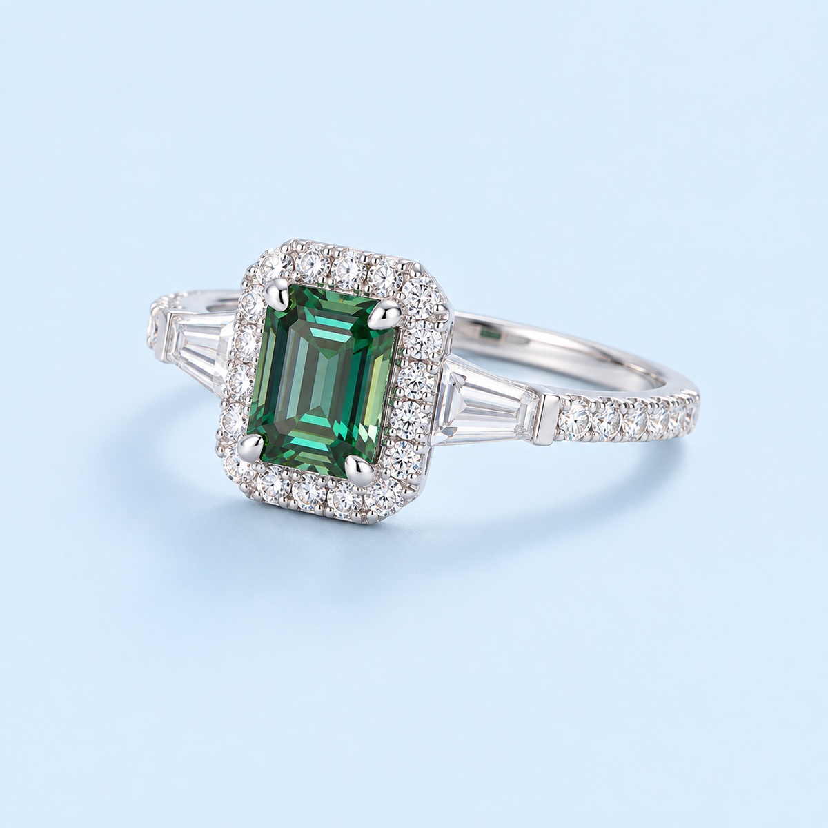 Senna emerald-cut green moissanite ring on a Riann Ashlyn blue background
