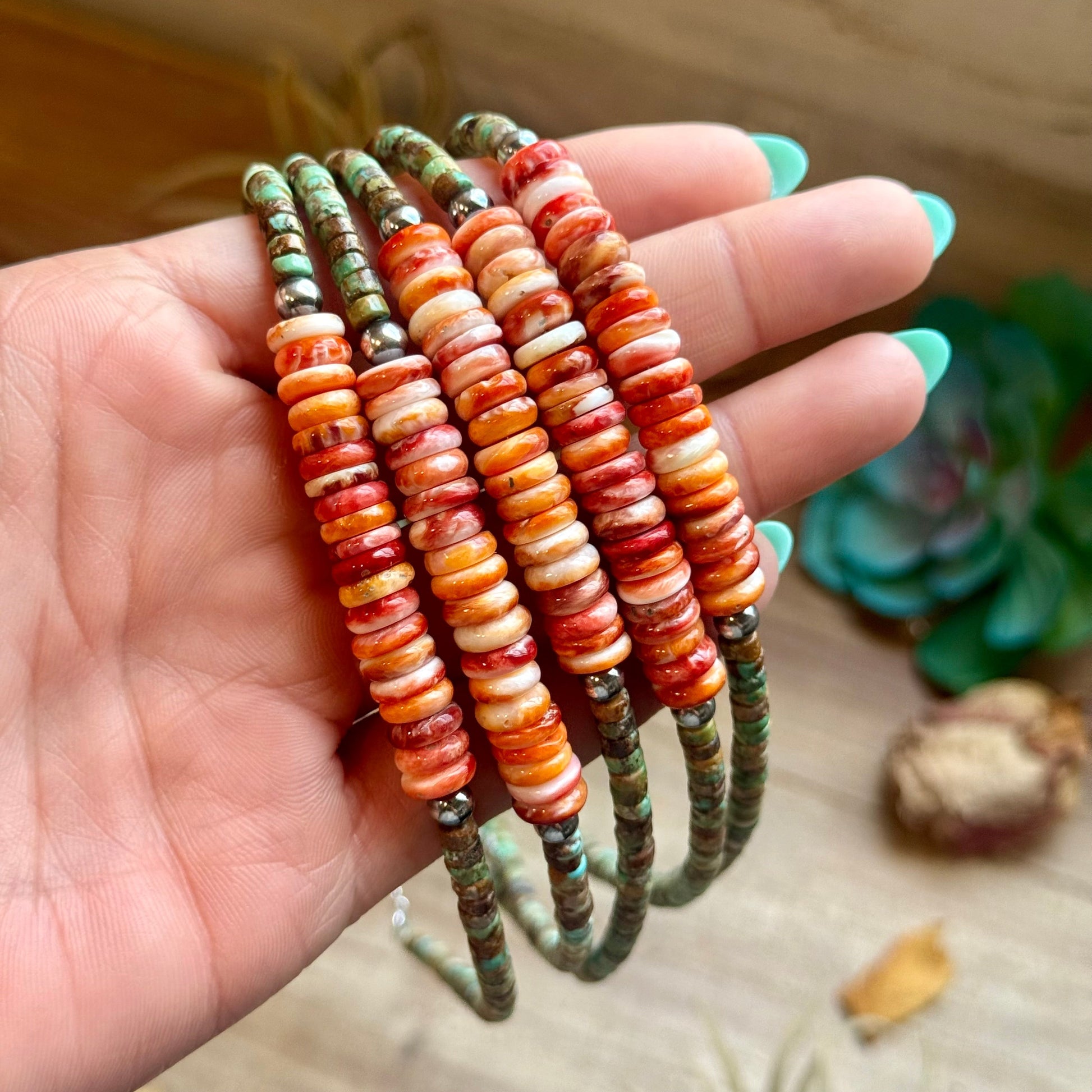     Multiple Sierra green turquoise and orange spiny oyster necklaces held in hand