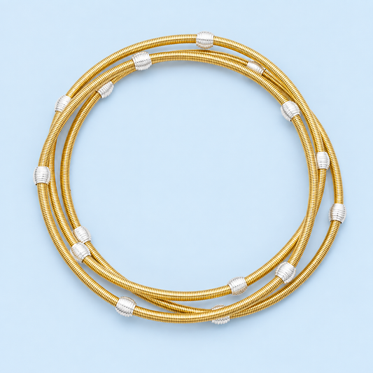 Sinclair gold-tone spring bracelets with silver-tone ribbed beads arranged on a pale blue background.
