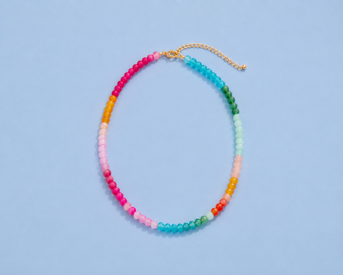 Soleil colorful beaded necklace arranged on a light blue background