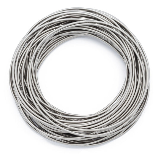 Zadie stainless steel spring bracelets arranged in an overlapping silver stack on white