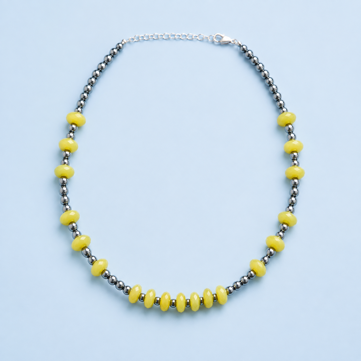 Zia faceted lemon jade and sterling silver pearl necklace on a light blue background